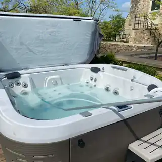 Hot tub with the lid folded back in a garden